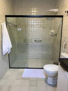 een badkamer met een glazen douche en een toilet bij Casa di Barra in Barra de São Miguel