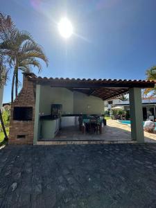 een huis met een patio met een grill en een tafel bij Casa di Barra in Barra de São Miguel