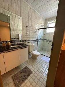 een badkamer met een toilet en een glazen douche bij Casa di Barra in Barra de São Miguel