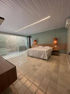 een grote slaapkamer met een bed en een plafond bij Casa di Barra in Barra de São Miguel