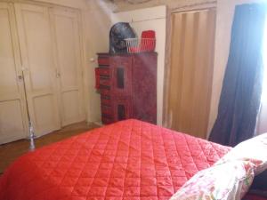 a bedroom with a red bed and a wooden dresser at NUEVA VIDA in Ciudad Lujan de Cuyo