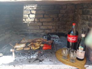 a grill with meat and vegetables and a bottle of coke at NUEVA VIDA in Ciudad Lujan de Cuyo