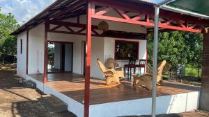 une terrasse couverte d'une maison avec des chaises et une table dans l'établissement Finca Ojo de Agua, à León