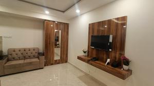 a living room with a couch and a flat screen tv at Hotel orchid inn in Bengaluru +16 photos