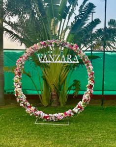 a wreath of flowers in front of a palm tree at Vanzara Retreat in Gurgaon