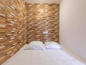 two pillows on a bed in a room with a brick wall at Studio Avoriaz, 1 pièce, 4 personnes - FR-1-314-272 in Morzine