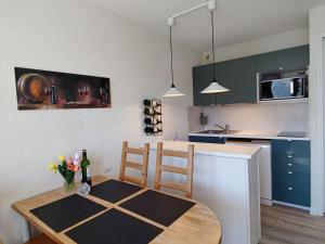 a kitchen with a table and a kitchen with blue cabinets at Studio Avoriaz, 1 pièce, 4 personnes - FR-1-314-276 in Morzine