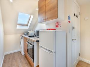 a small kitchen with a refrigerator and a sink at Apartment Six - Uk44288 in Arbroath