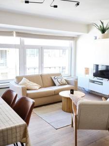 ein Wohnzimmer mit einem Sofa und einem TV in der Unterkunft Hugo by the harbor, light-filled and centrally located apartment - free parking in Ostende
