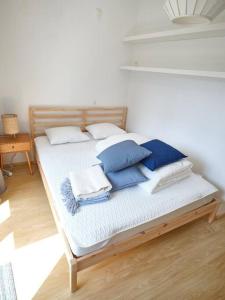 ein Bett mit blauen und weißen Kissen darauf in der Unterkunft Hugo by the harbor, light-filled and centrally located apartment - free parking in Ostende