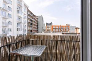 una mesa en un balcón con vistas a la ciudad en Hugo by the harbor, light-filled and centrally located apartment - free parking, en Ostende