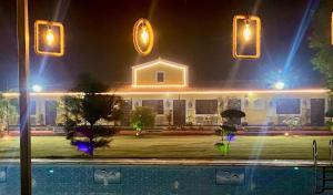 a house with lights above a swimming pool at night at Vanzara Retreat in Gurgaon