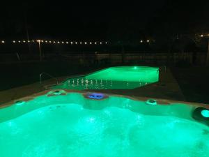 a hot tub with green lights in a backyard at night at Gulf Breeze Beach House w Pool Huge Hot Tub and Sauna in Oriole Beach