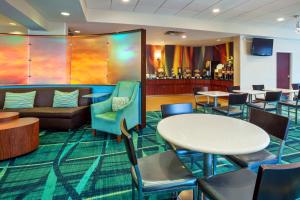 a lobby with tables and chairs and a bar at Springhill Suites by Marriott Chicago Schaumburg/Woodfield Mall in Schaumburg