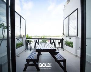 a patio with a bench and tables on a balcony at BOLD! apartment @ Riverside in Phnom Penh