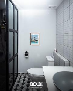 a white bathroom with a toilet and a sink at BOLD! apartment @ Riverside in Phnom Penh
