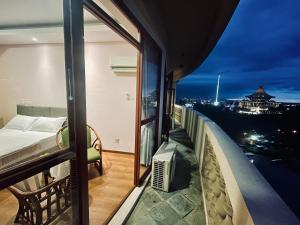 a balcony with a bed and a view of a city at Kuching City Center Riverbank Suites With Marvelous River View in Kuching