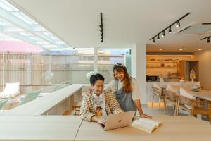 a man and woman sitting at a table with a laptop at The Tint At Phuket Town - SHA Plus in Phuket Town