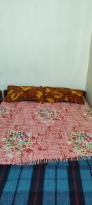 uma cama com um cobertor rosa em cima em A Budget Inn em Bodh Gaya