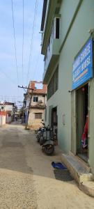 uma moto estacionada à porta de uma primeira casa em A Budget Inn em Bodh Gaya