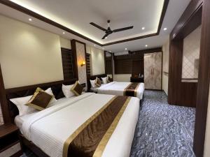 a hotel room with two beds and a ceiling fan at Hotel Mangalore Stay INN in Mangalore