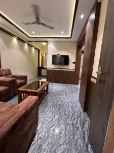 Hotel Mangalore Stay INN في منغالور: غرفة معيشة مع أريكة وتلفزيون