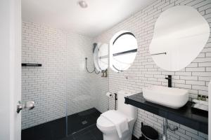 a white bathroom with a sink and a toilet at Mitt Haus (Lat Phrao Soi 5) in Bang Su