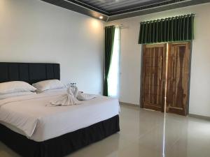 Un pat sau paturi într-o cameră la Pohon Purba Resort & Restaurant