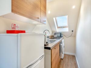 a small kitchen with a refrigerator and a sink at Apartment Five - Uk44289 in Arbroath