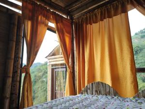 a bedroom with a bed and a large window at La Cabaña de Bambú in Manizales