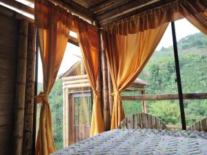 1 dormitorio con cama y ventana grande en La Cabaña de Bambú en Manizales