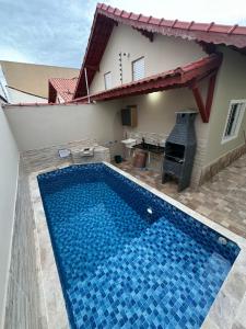 uma villa com uma piscina e uma casa em Casa na Praia com Piscina - Mongaguá - Drake House em Mongaguá
