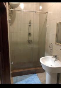 a bathroom with a shower and a sink at WILLS COURT in Accra