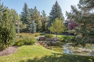 un jardin avec un ruisseau en face d'une maison dans l'établissement Villager Condo 1203 - Newly Remodeled and Resort Amenities, à Sun Valley