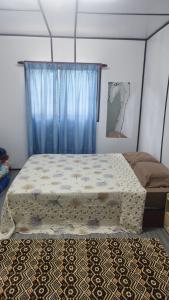 1 dormitorio con 1 cama con cortina azul en Inap Desa Hajah Yani, Kg Olak Lempit, en Banting