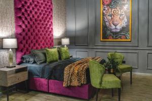 1 dormitorio con 1 cama y una pintura de un tigre en Hotel Osvé Boutique Cali en Cali