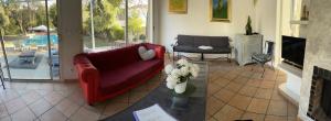 uma sala de estar com um sofá vermelho e uma lareira em LE BONHEUR AVEC PISCINE ET JARDIN em Cassis