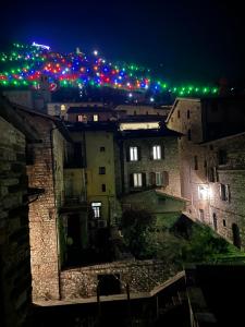 una vista di una città di notte con luci natalizie di L'Inferno di Dante a Gubbio