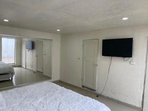 a bedroom with a bed and a flat screen tv on the wall at La casa de Mickey in Ciudad Juárez