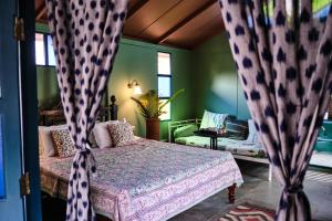 a bedroom with a bed with curtains in it at Bohemyan Blue Stay in Alibaug