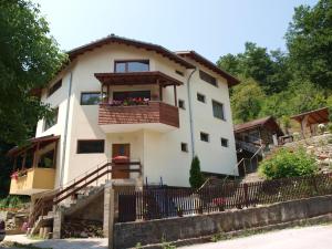 a house with a balcony with flowers on it at Sun House in Tryavna
