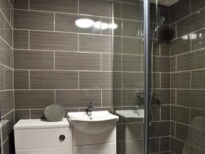 a bathroom with a toilet and a sink and a shower at The Granary in Woolaston