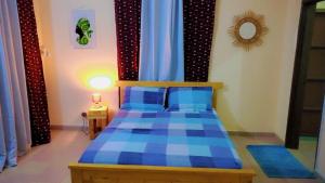 1 dormitorio con 1 cama azul en una habitación en Studio privatif spacieux en air de plage, en Cotonou