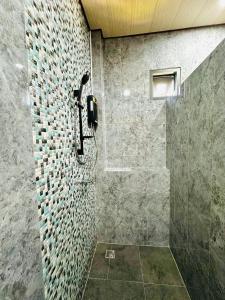 a shower with a phone on a stone wall at The Scenery Beach Resort in Baan Khai