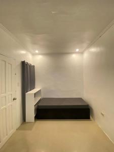 une chambre avec un lit dans le coin d'une pièce dans l'établissement Casa Luna 4 by Angelito's, à General Luna