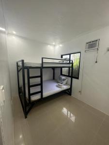 un lit superposé noir dans une pièce avec une fenêtre dans l'établissement Casa Luna 4 by Angelito's, à General Luna