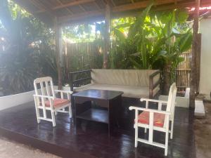 a table and two chairs and a couch on a porch at Casa Luna 4 by Angelito's in General Luna