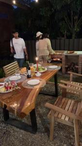 una mesa de picnic con platos de comida y gente a su alrededor en The woodshed village en Ban Ton Phung