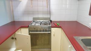 a kitchen with a stove and a red counter top at Private room with shared facilities W in Werribee