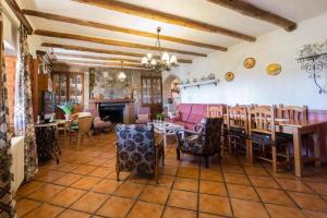 una sala da pranzo con tavoli, sedie e camino di Casas Rurales Noguericas ad Archivel